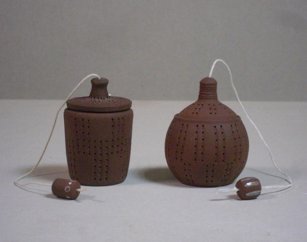 Infusettes (boules à thé) :  couleur chocolat (couleur de la terre). Une ficelle passe à travers le couvercle et une perle en poterie permet de retirer l'infusette de la théière.